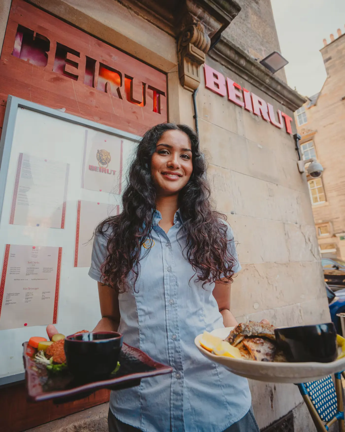 Waitress carrying dishes outside the Beirut Restaurant facade. Food photography by Gorka Di Capitan (gorkadicapitan.com).