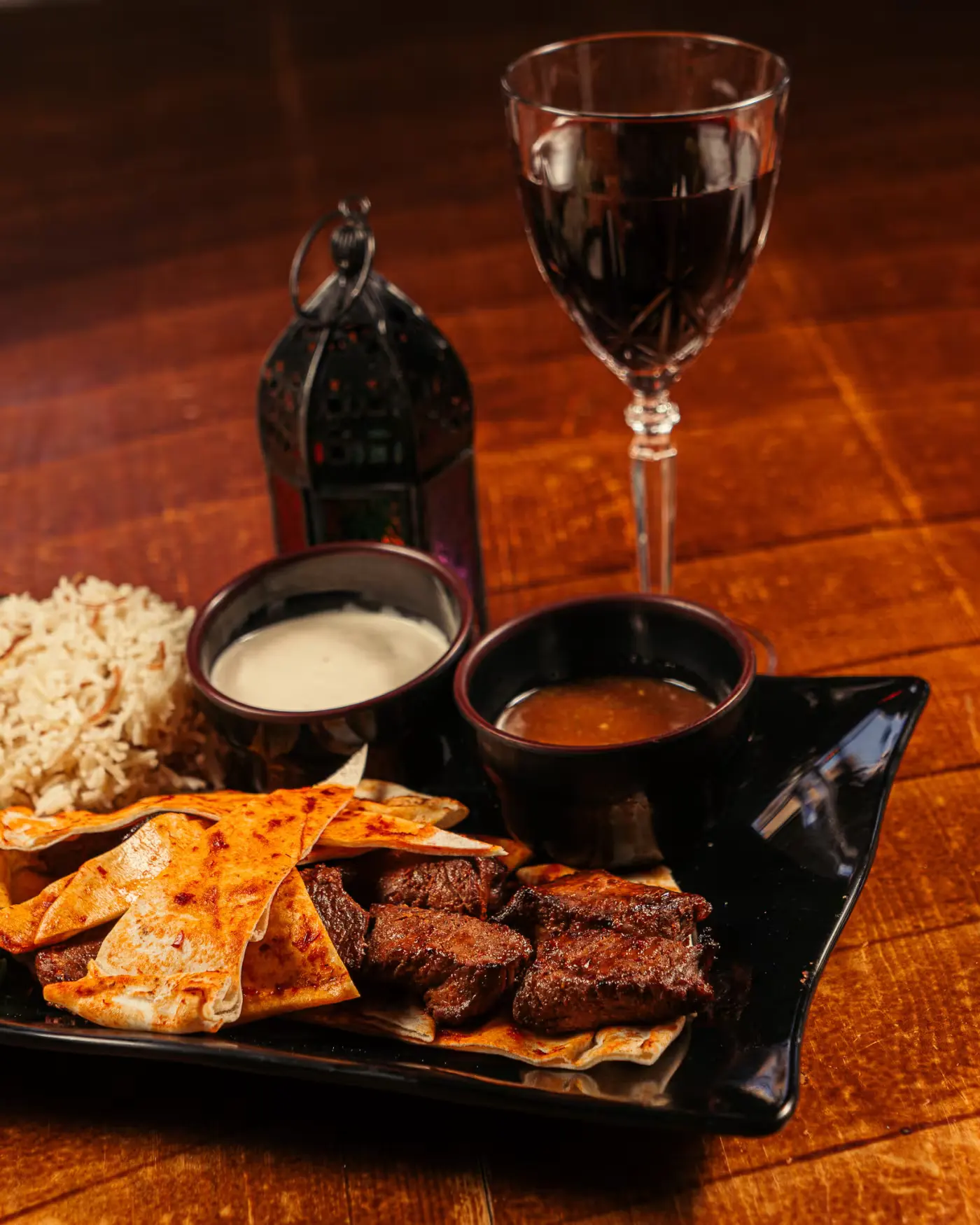 Grilled meats with rice, sauces and red wine at Beirut Restaurant. Food photography by Gorka Di Capitan (gorkadicapitan.com).