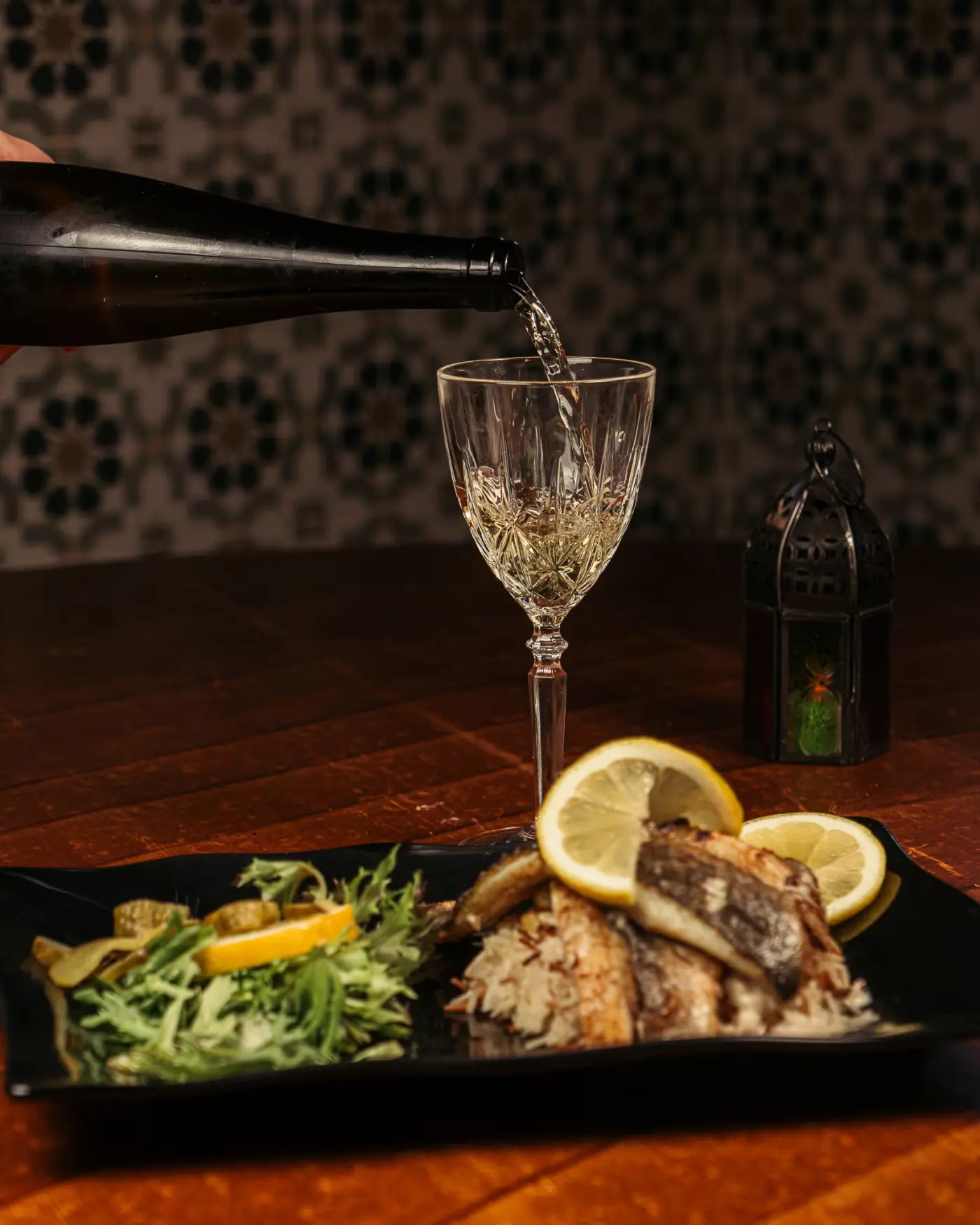 White wine poured beside a sea bass dish at Beirut Restaurant, captured by Gorka Di Capitan (gorkadicapitan.com), food photography