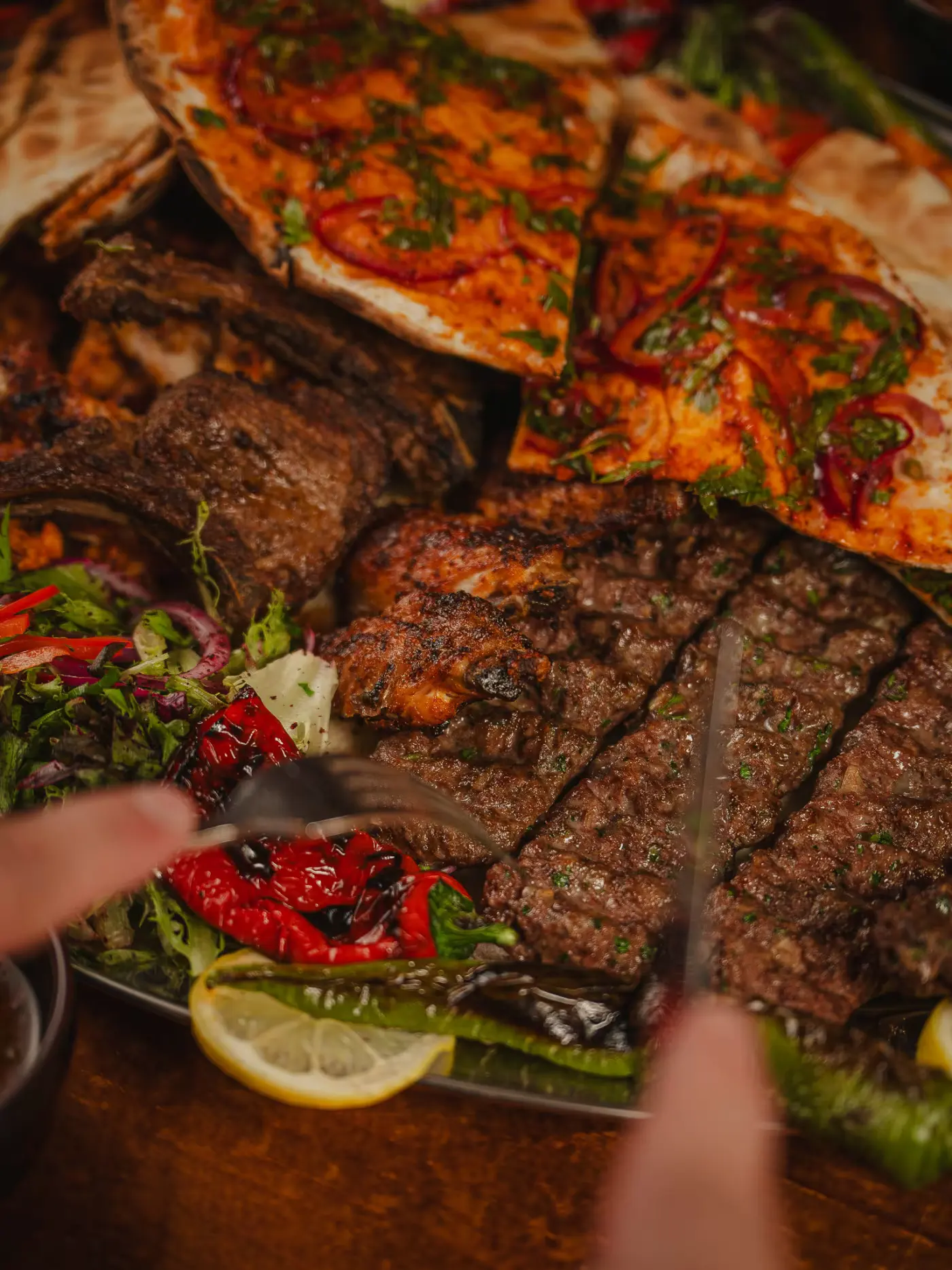 Knife and fork cutting into adana kebab on the mixed grill platter at Beirut Restaurant, food photography session by Gorka Di Capitan (gorkadicapitan.com)