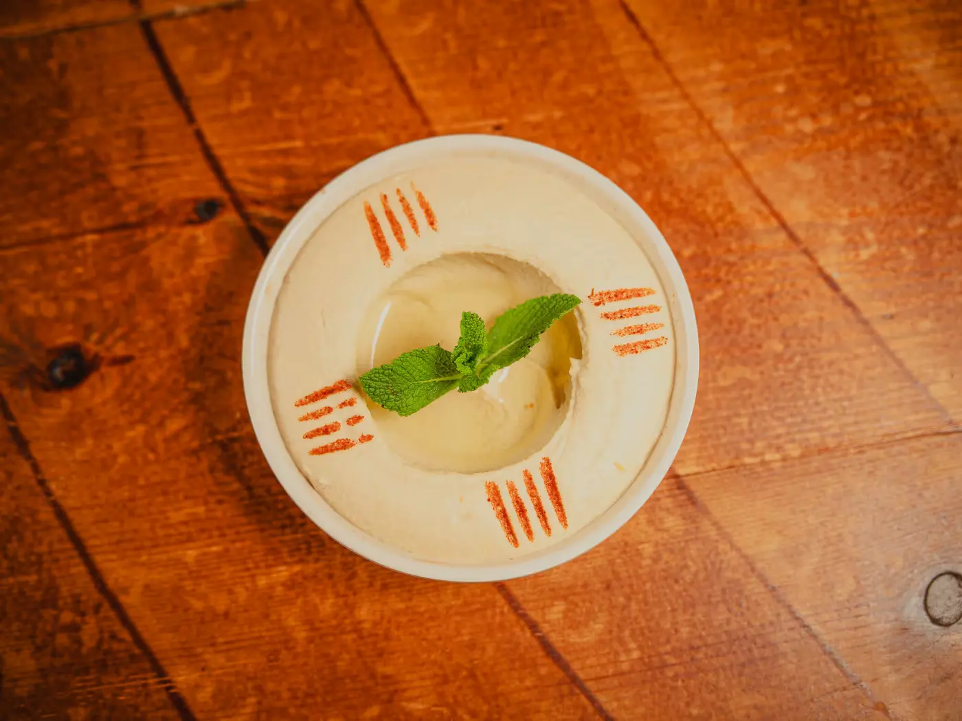 Overhead view of hummus finished with mint and paprika at Beirut Restaurant, food photography by Gorka Di Capitan (gorkadicapitan.com)