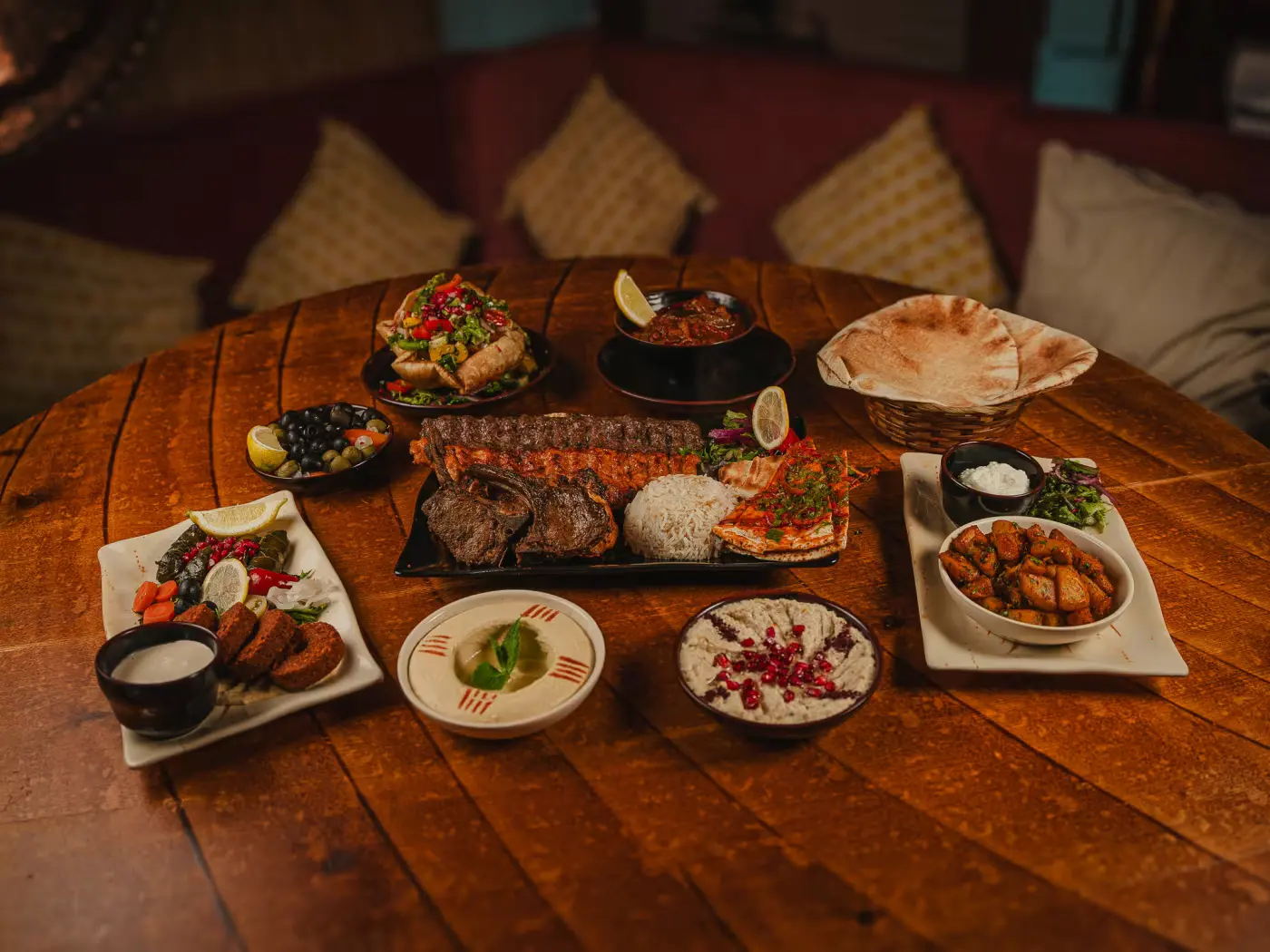 Mezze dishes spread across the wooden table between cushions at Beirut Restaurant, food photography by Gorka Di Capitan (gorkadicapitan.com)