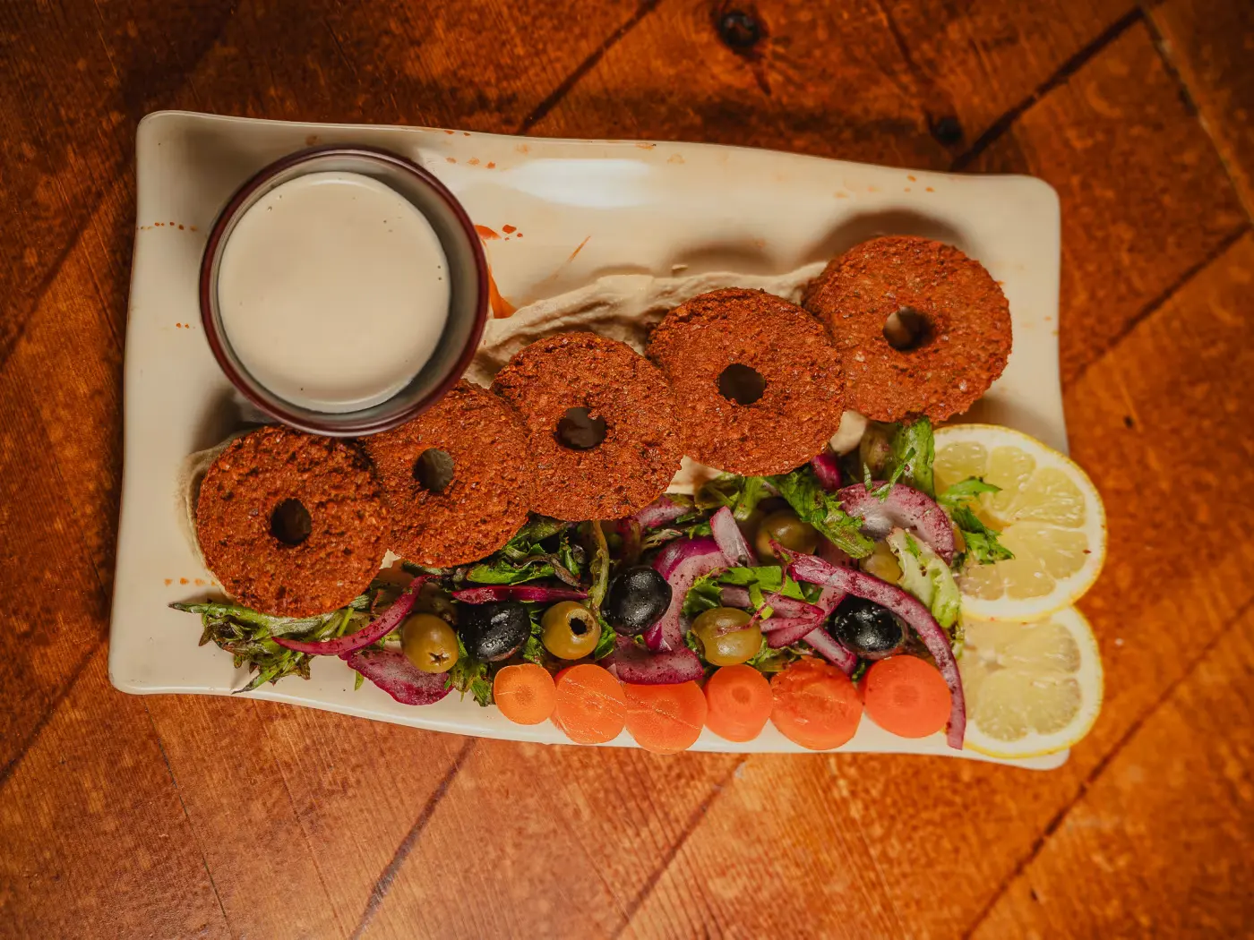 Falafel fingers with pickles, olives and lemon from above at Beirut Restaurant, food photography session by Gorka Di Capitan (gorkadicapitan.com)